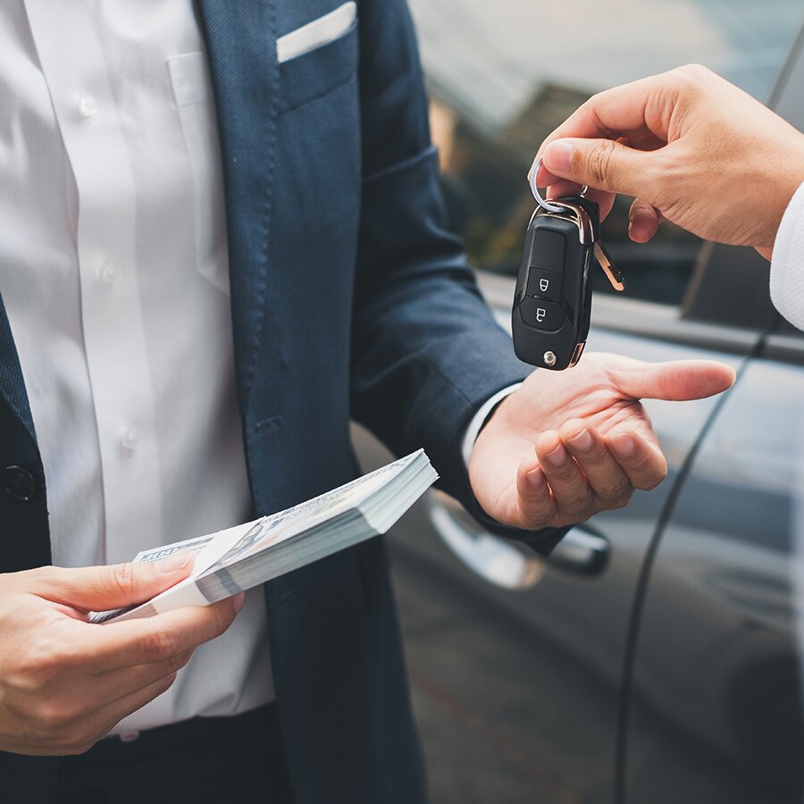 Handing car keys and cash—loan, credit, and sale concept